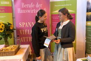 2 junge Frauen unterhalten sich an einem Messestand