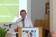 Mann steht am Rednerpult