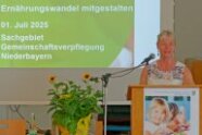 Frau steht an Rednerpult